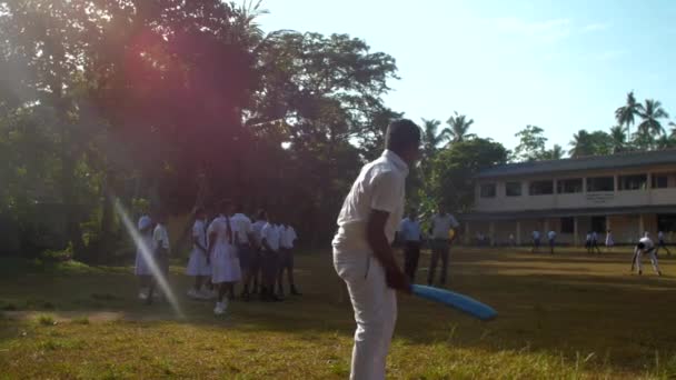 Un garçon cinghalais en uniforme scolaire rate le ballon de cricket — Video