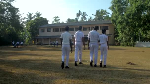 Schüler gehen zur Schule und hinterlassen Schatten auf Schulhof — Stockvideo