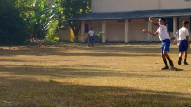 konsantre Sinhalese okul çocuğu topu atar