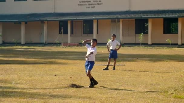 Estudante cingalês joga bola de críquete no playground — Vídeo de Stock