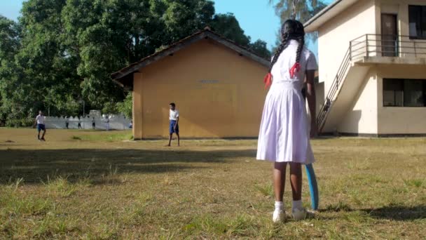 Singhalesisches Mädchen im weißen Kleid hält blauen Cricketschläger in der Hand — Stockvideo