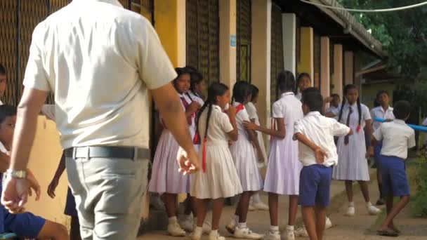 Sinhalese adam öğretmen üniformalı çocuklara geliyor — Stok video
