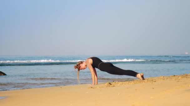 Blond flicka i svart träningsoverall Practices yoga pose Cobra — Stockvideo