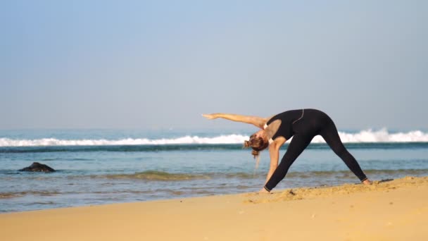 Lady med utrymme bullar praxis avancerad yoga pose triangel — Stockvideo