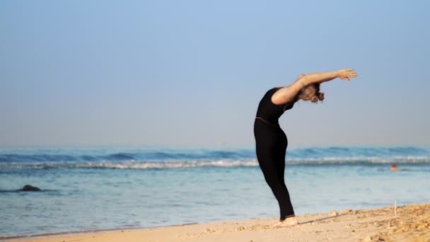 Sportig kvinna i träningsoverall Practices yoga pose halvmåne — Stockvideo