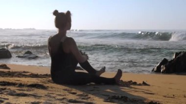 siyah eşofman genç bayan okyanus sahilinde meditasyon