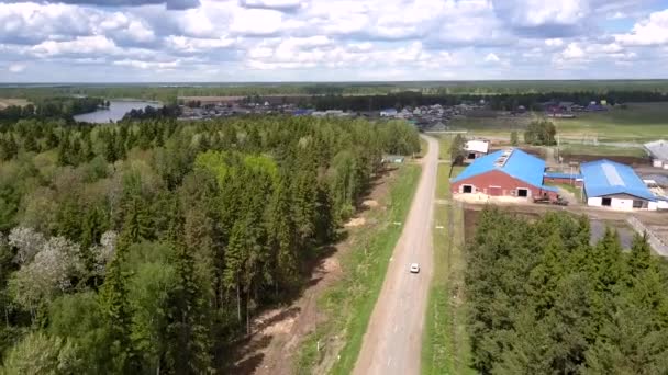 Carro branco dirige para casas modernas e azul lago aéreo — Vídeo de Stock