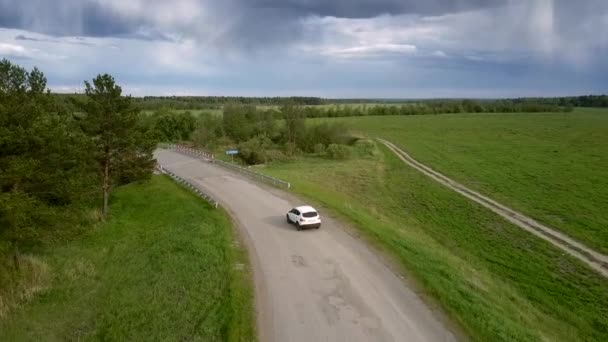 Witte moderne auto rijdt langs kleine brug over rivier — Stockvideo