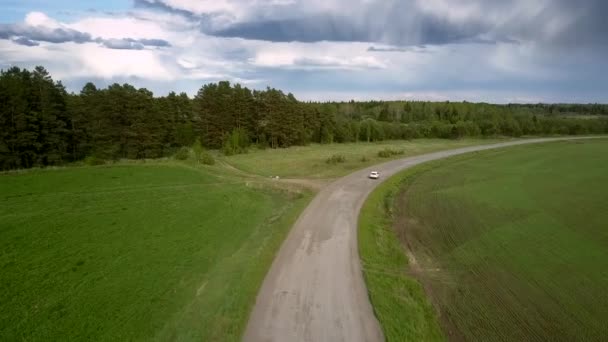 Witte moderne cross-over aandrijvingen langs kronkelende weg antenne — Stockvideo