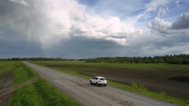 Auto moderne guida lungo la strada distrutta vicino campo vista superiore — Video Stock