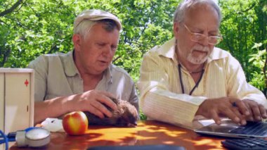 dizüstü bilgisayarda yaşlı vatandaş türleri ve kağıt üzerinde yazıyor