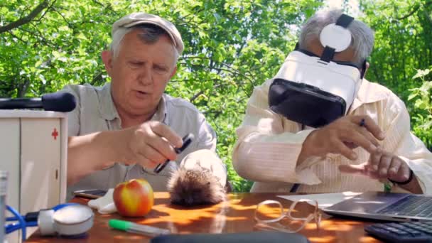 Nyugdíjas és idős ember vizsgálja sündisznó a kertben — Stock videók