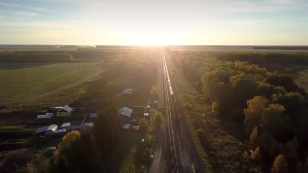 Luchtfoto goederentrein verplaatst naar de horizon bij zonsondergang — Stockvideo