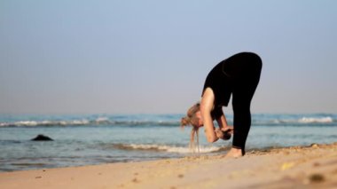 adil saçlı kadın kum plajda yoga nefes uygulamaları