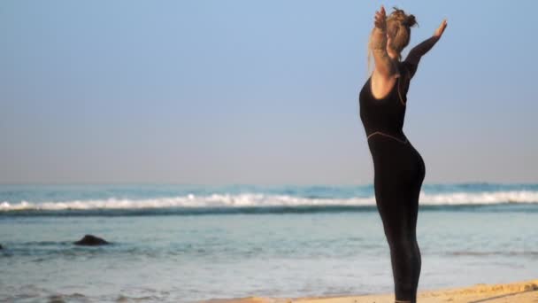 Dame en survêtement fait des exercices de respiration sur la plage de l'océan — Video