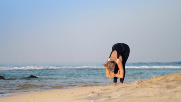 Blonde woman in black tracksuit practices breathing yoga — Stock Video