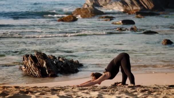 Fair haired kvinnlig praxis yoga pose nedåtgående vända hund — Stockvideo