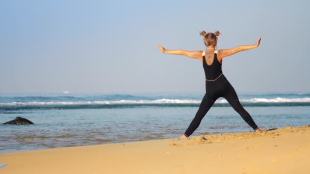 Meisje in zwarte trainingspak doet yoga pose draaide om zijhoek — Stockvideo