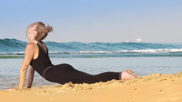 Bionda signora in tuta nera fa esercizi di stretching — Video Stock