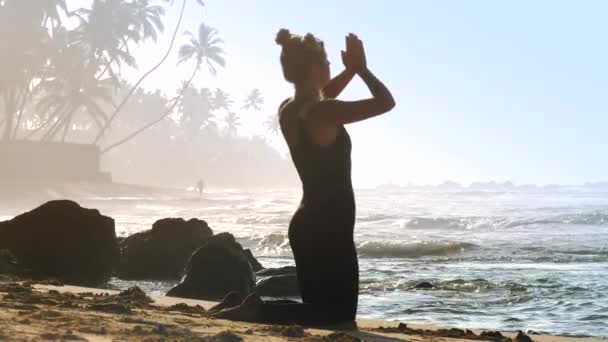 Chica con espacio bollos hace yoga backbend pose en ocean beach — Vídeo de stock