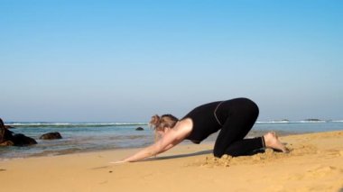 kumlu plajda siyah eşofman egzersizleri yalınayak kız