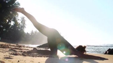 yaz güneşi ile aydınlatılmış plajda sportif kız siluet dengeleri