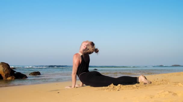 Босоніж леді розслабляється після вправ йоги на блакитному океані — стокове відео