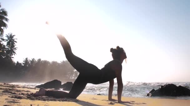 Slank meisje met ruimte broodjes mediteert in been omhoog yoga pose — Stockvideo