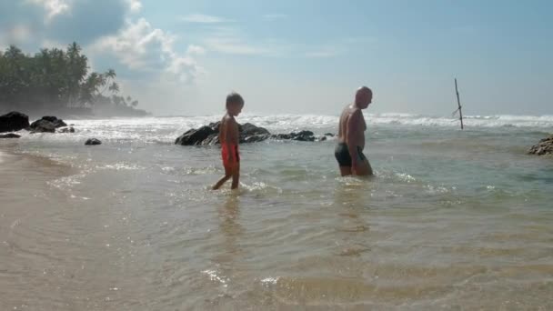 Boy with daddy rests in ocean at tropical resort slow motion — Stock Video