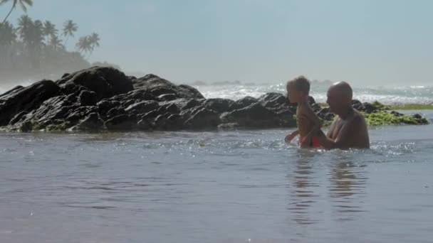 Papi ayuda hijo saltar en calma agua de mar en exótico resort — Vídeo de stock