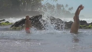 baba ve oğlu tropikal tatil yavaş hareket sıcak denizde oynamak