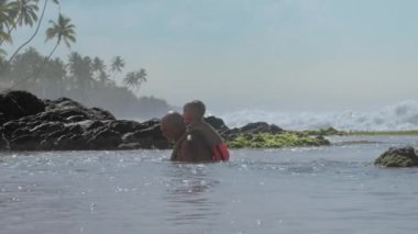 küçük oğlu ile pozitif adam sakin okyanus suyunda eğlenin