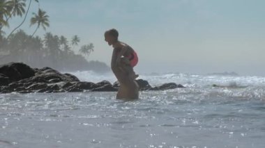 çocuk mavi gökyüzüne karşı baba omuzlarından okyanusa atlar