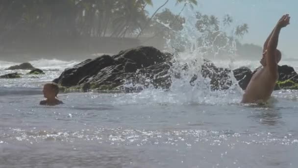 Padre e hijo pequeño descansan en el océano azul en el resort tropical — Vídeo de stock