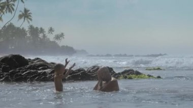 küçük çocuk kayalarda yüzen baba okyanus suyu sıçramaları