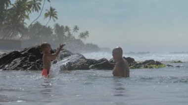 sevimli oğlu ve babası birlikte deniz suyunda oynarken zaman harcamak