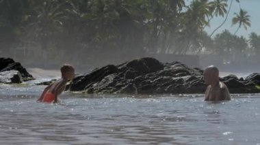 çocuk güneşli bir günde sıcak okyanus koyunda baba ile oynar