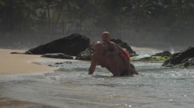 baba sahilde denizde geri küçük çocuk taşıyan eğlenceli