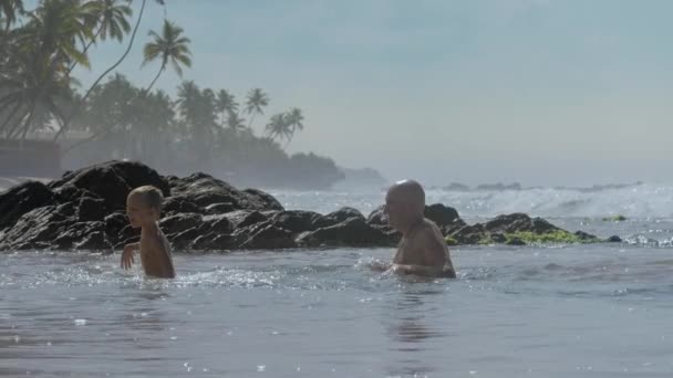 爸爸泼水可爱的男孩在温暖的海洋游泳 — 图库视频影像