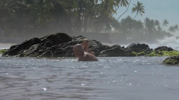 Divertido chico sube en padre espalda jugando en azul océano agua — Vídeos de Stock