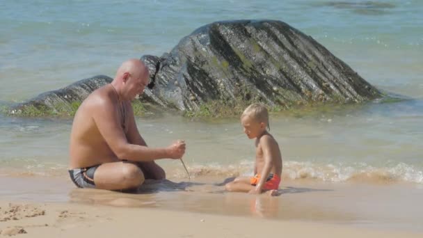 Familia de papá y niño pequeño pasa en la costa tropical del océano — Vídeos de Stock