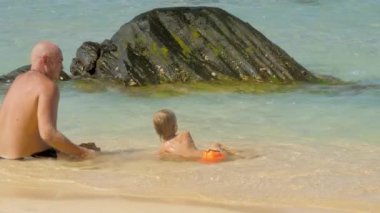 çocuk taşların yakınında daha uzak kontrol altında berrak suda yüzer