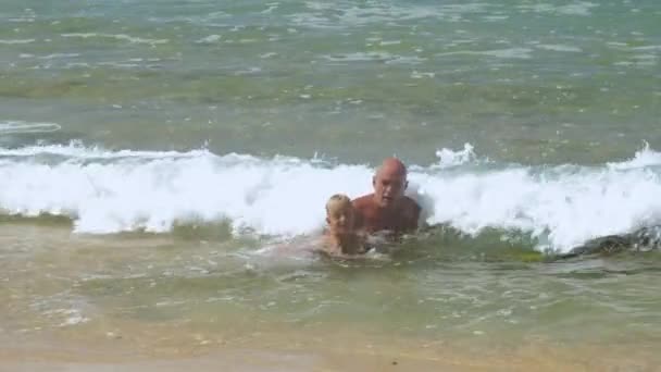 Daddy speelt met zoon in glooiende zee golven in exotische resort — Stockvideo