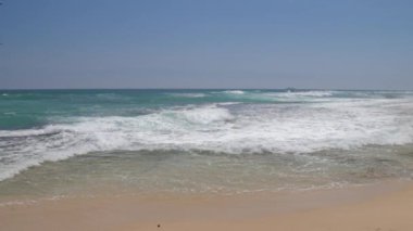 deniz dalgaları mavi gökyüzü yavaş hareket altında tropikal plajda rulo