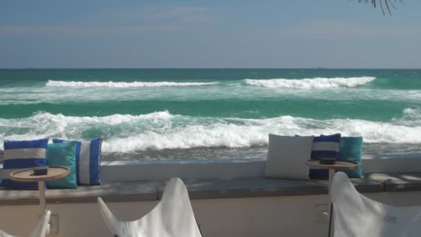 Café con mesas contra el hermoso océano azul cámara lenta — Vídeos de Stock