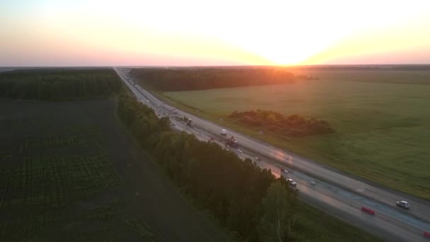 Snelweg vernieuwing tussen brede velden in de avondlucht foto — Stockvideo