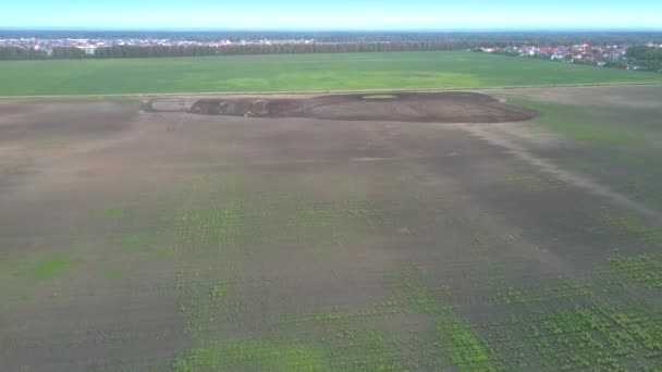 mouvement aérien au-dessus du champ vers un petit tracteur cultivant le sol 