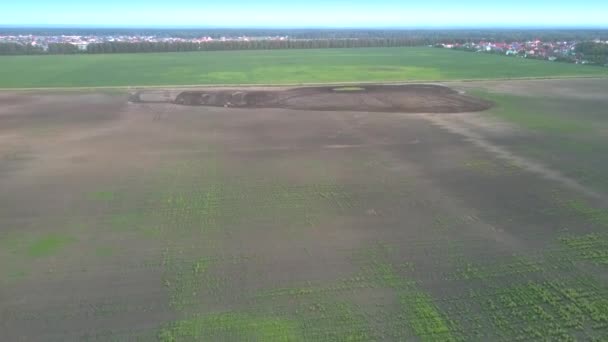 Luftbewegung über Feld zu kleinem Traktor, der Erde anbaut — Stockvideo