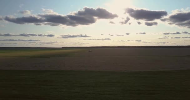 Панорамный вид на осеннее поле с современным комбайном — стоковое видео