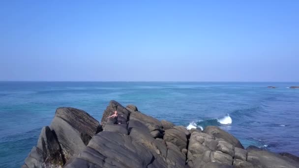 Meisje beoefent yoga op Cliff bij schuimende oceaan golven — Stockvideo